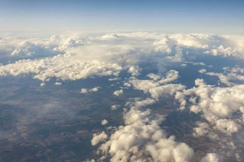 View of Earth and clouds from a window of the flying plane Stock Photos