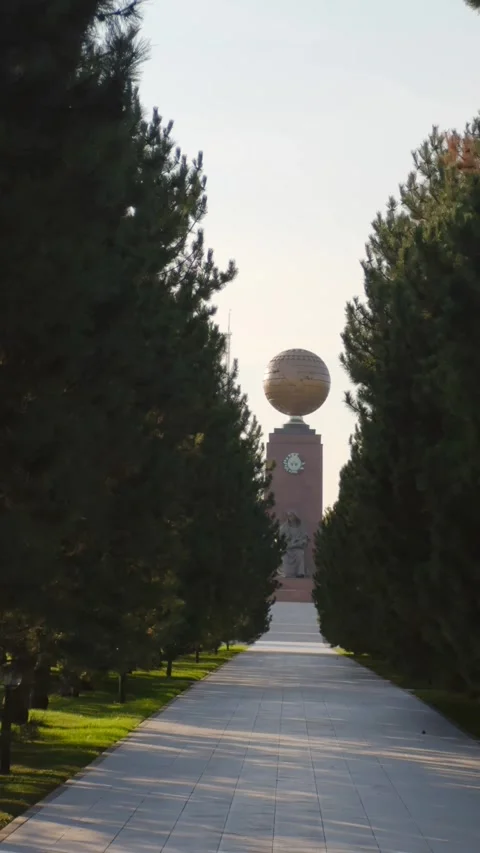 View of the Earth Monument through green alley in park in Tashkent, Uzbekistan Stock Footage 318634948