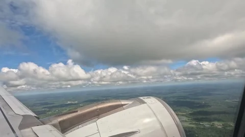 View of Earth through Airplane Window with Clouds and Landscape Below Stock-Footage 339893419