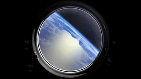 A view of the Earth through the porthole of a spacecraft. Earth is moving away Stock Footage 113967892