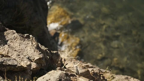 View from edge of cliff on water below, water hits rocks Stock Footage 127405429