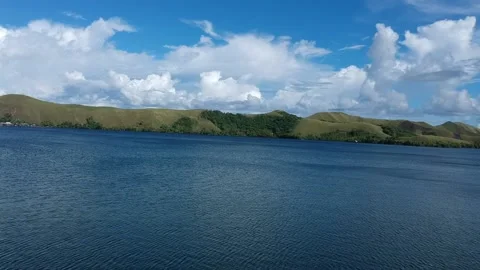 View on the edge of the lake where there is a green mountain using a drone Video stock 235479474