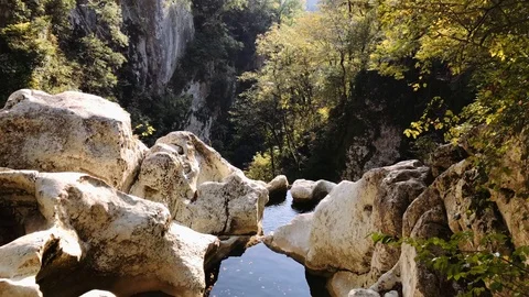 View of the edge of a rocky forest waterfall on a sunny summer day. Stock Footage 106853661