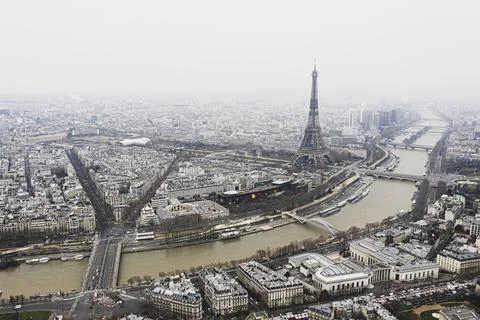 View on Eiffel tower and the river over the roofs of Paris on a grey cloudy d Fotos Stock