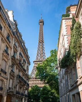 View of Eiffel Tower between buildings on street in Paris, France. Stock Photos