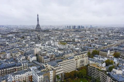View on Eiffel tower over the roofs of Paris on a grey cloudy day Stock Photos