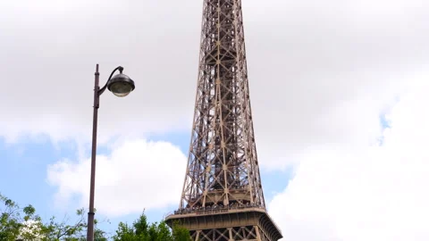 View At Eiffel Tower In Paris With Trees And Street Lamp In The Foreground Stock Footage 260695817