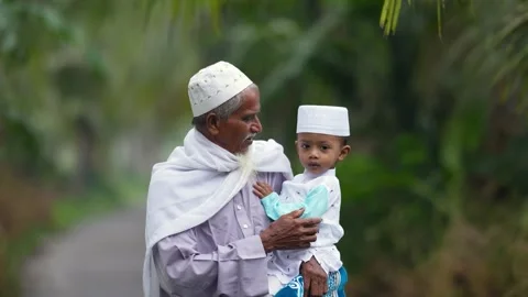 View of an elderly man holding a young boy in Bogura, Bangladesh. Video stock 334991830
