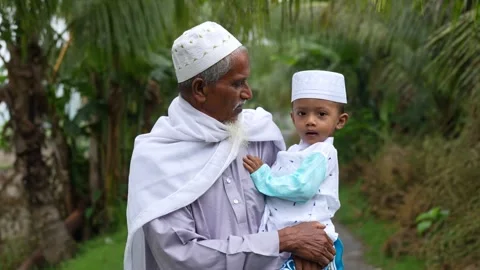 View of an elderly man holding a young boy in Bogura, Bangladesh. Video stock 334991985