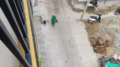 View of a Elderly Woman Throwing Garbage Beside Concrete Road in Outdoor Ur.. Stock Footage 330062085