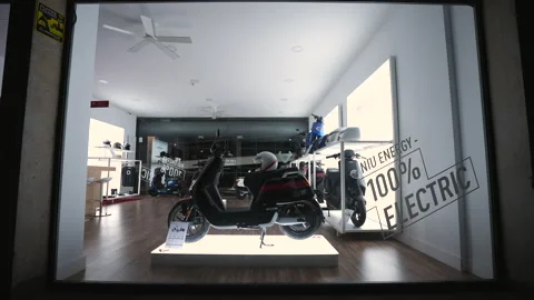 View at electrical engine powered scooter through store show case at evening. Stock Footage 170083441