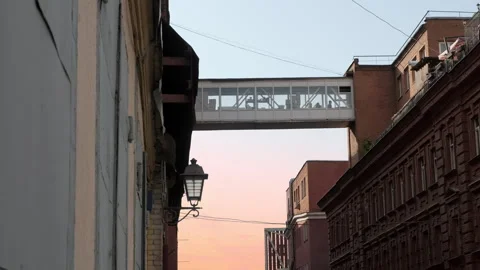 View of elevated passage between buildings against background of sunset sky. Red Stock Footage 243362556