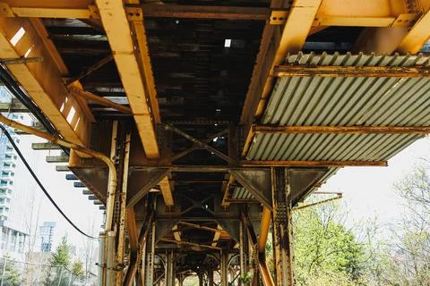 View of an elevated train track and support structure in a city, showing me.. Фото