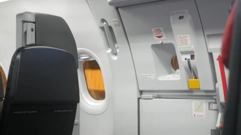View to emergency exit door with airplane empty seat row witout any passenger Stock Footage 337008195
