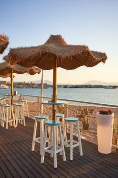 View on empty bar table against sunset at the beach. Summer time in Italy. Stock Photos