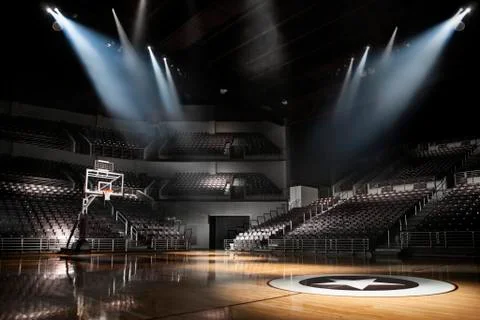 View of empty basketball arena with dramatic lighting from on the court with Stock Photos