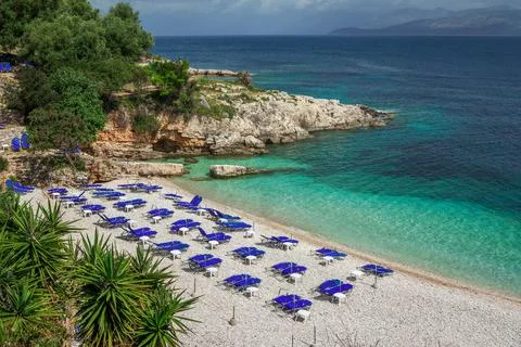 View of empty beach - blue deck chairs and umbrellas Stock Photos