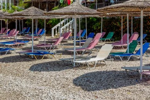 View of empty beach -  colorful sun beds and umbrellas Stock Photos