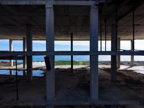 View of an empty building framework overlooking the ocean during the day with a Fotos de archivo