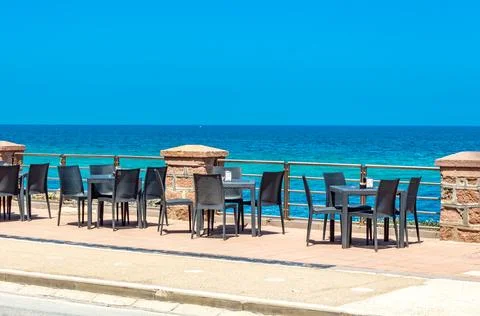 View at empty chairs of cafe during pandemic in Porto Torres Sardinia Stock Photos