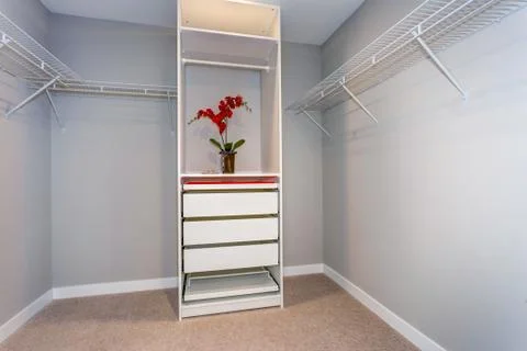 View of empty closet interior with shelves and white cabinet. Stock Photos