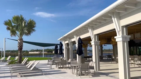 View of empty outdoor cafe with sunbeds and tables Stock Footage 235667936