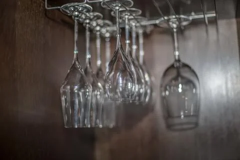 View with empty red wine transparent glass cups stand upside down in bar Stock Photos
