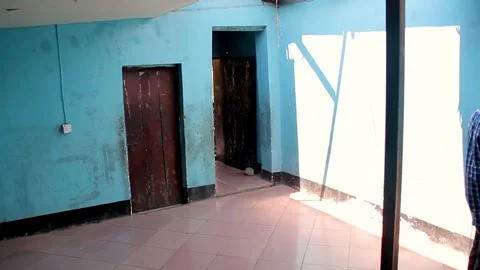 A view of an empty room featuring bright blue walls, a dark wooden door, a Stock Footage 345835587