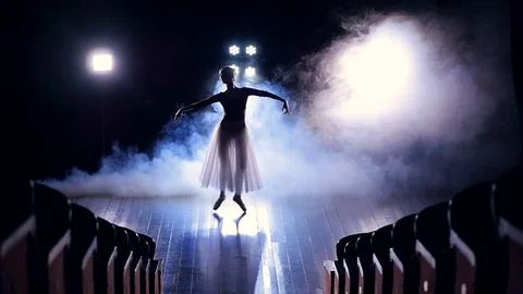 A view from empty seats to a jumping ballerina. Stock Footage