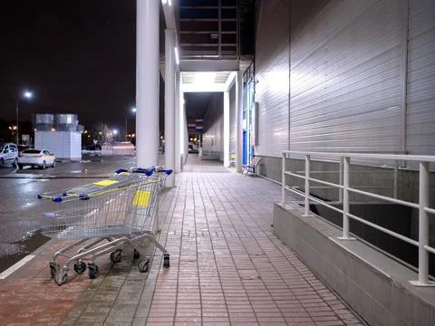 View of empty shopping carts outside the store at night. Stock Photos