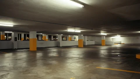 A view of empty underground parking, brightly lit with ceiling lamps. Stock Footage 286255477