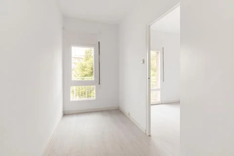 View of an empty white bright room with window without furniture after painting Фото