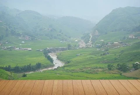 The view of the empty wooden table with a farmer village with a river running Stock Photos