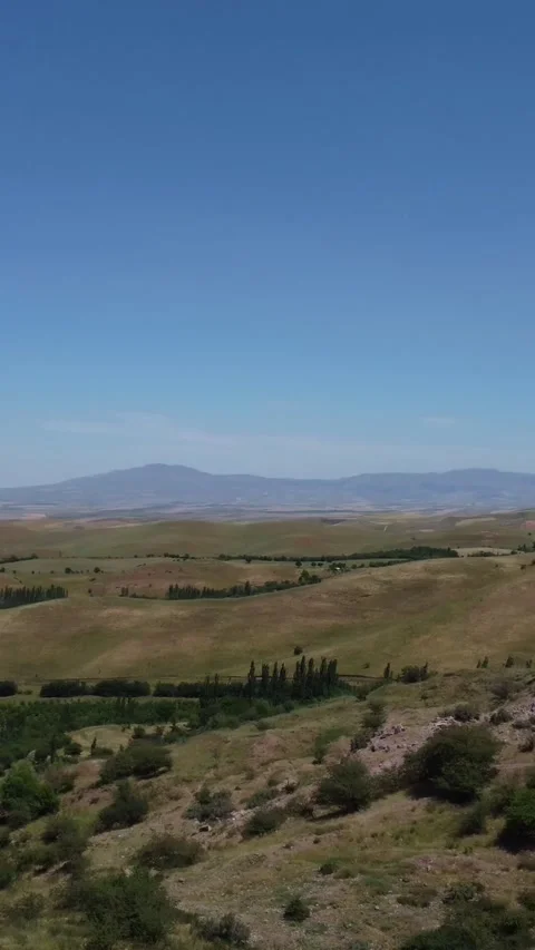 View of endless sun bleached fields and distant mountain ridges in Kazakhstan Видео 338124208