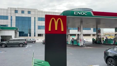View of ENOC petrol pump and Mc Donald sign board dubai al barsha area Stock Footage 233854484