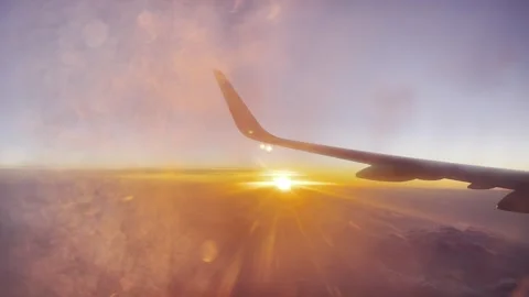 View of evening orange sunset sky with clouds from blurred frozen plane porthole Stock Footage 278701720