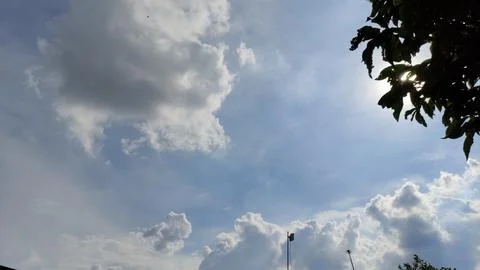 The view of the evening sky, the sun covered with white and black clouds. Stock Photos