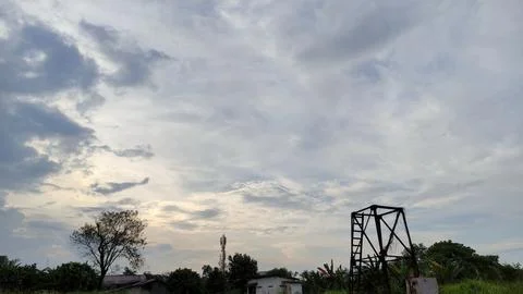 The view of the evening sky, the sun covered with white and black clouds. Stock Photos