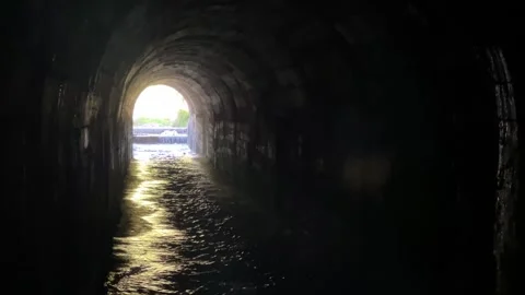 A view of the exit from the dark tunnel where the water flows. Stock Footage 273192431