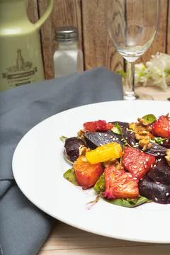 View of exquisite beetroot, orange, walnut and arugula salad with olive oil Stock Photos