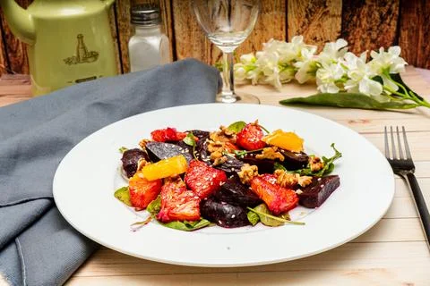 View of exquisite beetroot, orange, walnut and arugula salad with olive oil Stock Photos