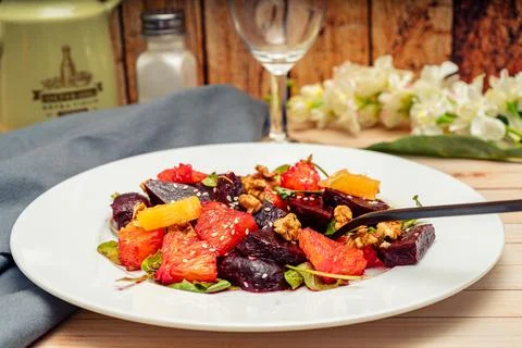 View of exquisite beetroot, orange, walnut and arugula salad with olive oil Stock Photos