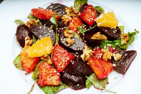 View of exquisite beetroot, orange, walnut and arugula salad with olive oil Stock Photos