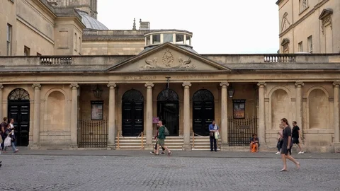 View of the exterior to the Roman Baths building with people walking by Stock Footage 112666404