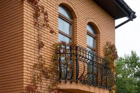 View of the facade of the building in the city, red brick house balcony Stock Photos