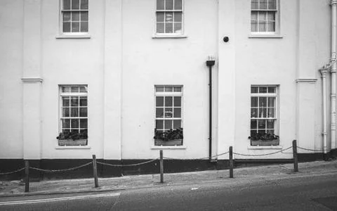 View to facade of building with windows with colored wooden shutters. The con Stock Photos