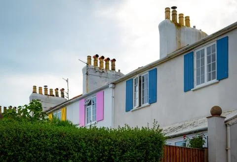 View to facade of building with windows with colored wooden shutters. The Stock Photos