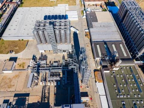 A view of a factory complex featuring several large silos and various process Stock Photos