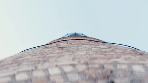 A view of a factory stack from below and then a sad girl is seen next to its Stock Footage 90806512
