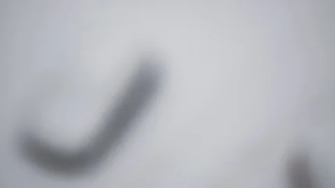 View of the falling snow on the background of a blurred snow-covered car Stock Footage 117287598